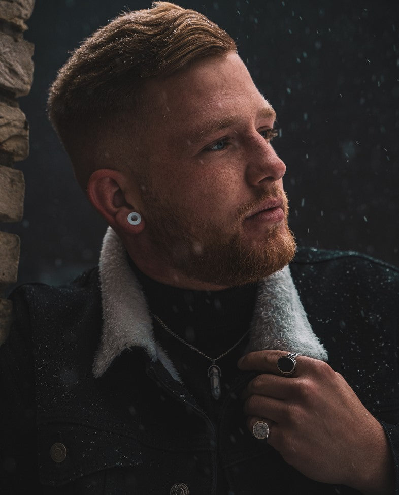 schwarzer und goldener siegelring auf der hand